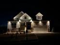 Beautiful new home with stone accents and illuminated outdoor lighting at night at 231 Laurel Vista Dr, Canton, GA 30114
