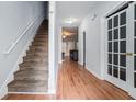 Inviting hallway with hardwood floors, staircase, and white trim, leading to other rooms in the home at 2735 Snapfinger Mnr, Decatur, GA 30035