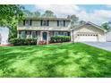 Inviting home featuring a lush front lawn, attached garage and traditional architectural elements at 1206 Tred Avon Sw Way, Lilburn, GA 30047