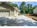 Attached garage exterior with driveway and landscaped walkway leading to backyard at 1206 Tred Avon Sw Way, Lilburn, GA 30047