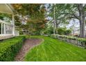 Lush front yard with a meticulously maintained lawn, mature trees, and a charming picket fence at 132 East Ne Dr, Atlanta, GA 30305