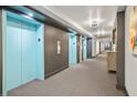 Hallway with elevators featuring modern lighting, neutral tones and contemporary art at 620 Peachtree Ne St # 1716, Atlanta, GA 30308