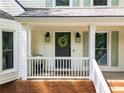 Welcoming front porch with decorative wreath and lantern lighting, framed by white railings and brick accents at 3306 Emory Dr, Marietta, GA 30062