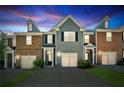 Charming townhome with a well-manicured lawn and attached garage at dusk at 5221 Sherwood Way, Cumming, GA 30040