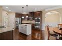 Modern kitchen with stainless steel appliances, granite countertops, an island, and dark wood cabinetry at 5805 Fielding Ct, Cumming, GA 30041
