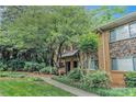 Inviting brick townhome with stone accents and lush landscaping, providing a serene and welcoming curb appeal at 100 Biscayne Nw Dr # A1, Atlanta, GA 30309