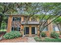 Charming brick townhome featuring stone accents and a well-manicured front yard with mature trees and lush greenery at 100 Biscayne Nw Dr # A1, Atlanta, GA 30309