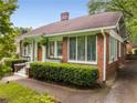Side view of a red brick home featuring well-maintained landscaping and unique stained-glass windows at 239 Kings Hwy, Decatur, GA 30030