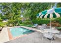 Relaxing pool area with mature landscaping, an umbrella table and several lounge chairs for easy outdoor living at 239 Kings Hwy, Decatur, GA 30030