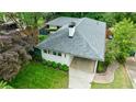 Aerial view showcasing a well-maintained white home with a grey roof, landscaped yard, and covered driveway at 2298 Pembrook Pl, Atlanta, GA 30324