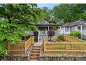 Attractive bungalow showcases a quaint front porch, lovely landscape design, and delightful wooden fencing at 1063 Manigault Se St, Atlanta, GA 30316