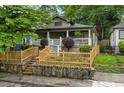 Inviting bungalow home featuring a charming front porch, wooden fence, and beautifully landscaped yard at 1063 Manigault Se St, Atlanta, GA 30316