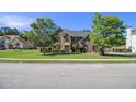 Beautiful brick home featuring a large lawn, mature trees, and a charming facade at 4765 Smokestone Dr, Douglasville, GA 30135