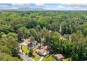 Expansive aerial view of a home surrounded by lush greenery and mature trees with a distant view of mountain at 3050 Woodland Nw Dr, Kennesaw, GA 30152