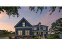 Beautiful two-story blue house at dusk with landscaped front yard, offering charm and curb appeal at 4035 Pinebrook Cir, Cumming, GA 30028