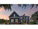 Charming two-story home with gray siding, white trim, manicured lawn and landscaped front yard at sunset at 4035 Pinebrook Cir, Cumming, GA 30028