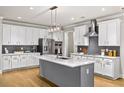 Kitchen with white cabinets, stainless steel appliances, an island, and modern lighting at 4093 Groveland Park Dr, Powder Springs, GA 30127