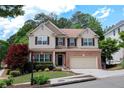 Inviting two-story home with a brick facade, tidy landscaping, and an attached two-car garage at 139 Lake Reserve Way, Canton, GA 30115