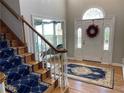 Grand foyer featuring a hardwood floor, elegant staircase with a decorative runner, and a decorative glass door at 5440 Cameron Forest Pkwy, Johns Creek, GA 30022