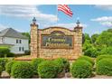 Stone entrance sign for Cramac Plantation with American flag waving overhead on a sunny day at 771 James Cir, Lawrenceville, GA 30046