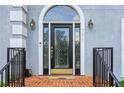 Elegant front door with decorative glass, brick steps, and stylish exterior lighting at 771 James Cir, Lawrenceville, GA 30046