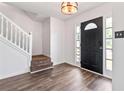 Inviting foyer boasts hardwood floors, a staircase with white railing and a black door with sidelights at 4148 Kings Cswy, Ellenwood, GA 30294