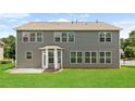 Spacious backyard with lush green lawn, gray siding, and a concrete patio, perfect for outdoor gatherings at 3366 Bridge Walk Dr, Lawrenceville, GA 30044