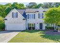 Charming two-story home with painted brick, black shutters, well-manicured lawn, and attached two-car garage at 1755 Waters Ferry Dr, Lawrenceville, GA 30043
