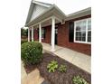 Welcoming brick home with white columns, a covered porch, and a beautifully landscaped yard at 401 Courtyard Ter, Woodstock, GA 30189