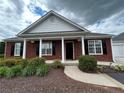 Charming brick home with black shutters, a covered porch, and manicured landscaping at 401 Courtyard Ter, Woodstock, GA 30189