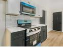 Modern kitchen with stainless steel appliances, white subway tile, and dark cabinets at 102 Aristocratic Way, Locust Grove, GA 30248