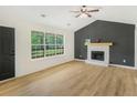 Bright living room with fireplace, large window, and hardwood floors at 102 Aristocratic Way, Locust Grove, GA 30248