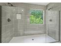 Modern tiled shower with dual showerheads and natural light from window at 102 Aristocratic Way, Locust Grove, GA 30248