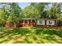 A charming single-story brick house with a well-maintained lawn and mature trees in a serene setting at 2279 Parkview Cir, College Park, GA 30337