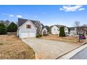 A charming home with stone accents, a manicured lawn, and a long driveway at 2738 Lakewater Way, Snellville, GA 30039