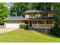 Charming two-story home boasts a brick front, attached garage, a welcoming porch, and a meticulously maintained lawn at 28 Indian Branch Way, Lawrenceville, GA 30043