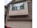 Home exterior with garage and bay window, showcasing brick and siding details at 101 Dewey Rd, Lilburn, GA 30047
