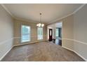 Formal dining room featuring elegant chandelier, carpeting, and natural light from large windows at 2001 Fairbrook Ln, Woodstock, GA 30189