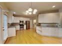 Spacious kitchen with stainless steel appliances, white cabinets, and wooden floors at 2001 Fairbrook Ln, Woodstock, GA 30189