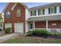 Inviting two-story townhome with a covered front porch, brick accents, and lush landscaping at 210 Cottonwood Creek Cir, Canton, GA 30114