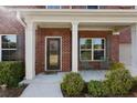 Charming front porch with white columns, brick facade, and space for outdoor seating at 211 Parc Dr, Canton, GA 30114