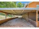 Covered carport with gravel driveway and rustic log home exterior at 1795 Hutcheson Ferry Rd, Whitesburg, GA 30185