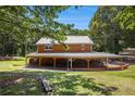 Charming two-story home with a metal roof and expansive covered veranda at 1795 Hutcheson Ferry Rd, Whitesburg, GA 30185