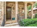 Elegant home entryway with stone accents, a dark wood door, and wrought iron railings at 2672 Brickell Square, Atlanta, GA 30341