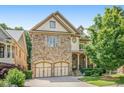 Charming stone-front home featuring an attached two-car garage and inviting curb appeal at 2672 Brickell Square, Atlanta, GA 30341