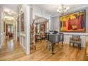 Elegant living room featuring hardwood floors, artwork, a piano, and views into the dining room at 2672 Brickell Square, Atlanta, GA 30341