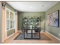 A stylish office with a desk, shelving, light green walls, and hardwood floors at 720 Hedwig Dr, Mcdonough, GA 30252