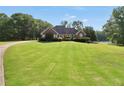 Beautiful lakeside home surrounded by a vast, well-manicured lawn and mature trees at 70 Lake Charles Xing, Covington, GA 30016