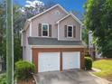 Side view of a two-story home with neutral siding, brick accents, and a two-car garage at 164 Stoneforest Dr, Woodstock, GA 30189