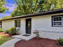 Charming home exterior featuring a black front door and landscaped yard with lovely flower bushes at 1819 Waldrep Se Cir, Marietta, GA 30060